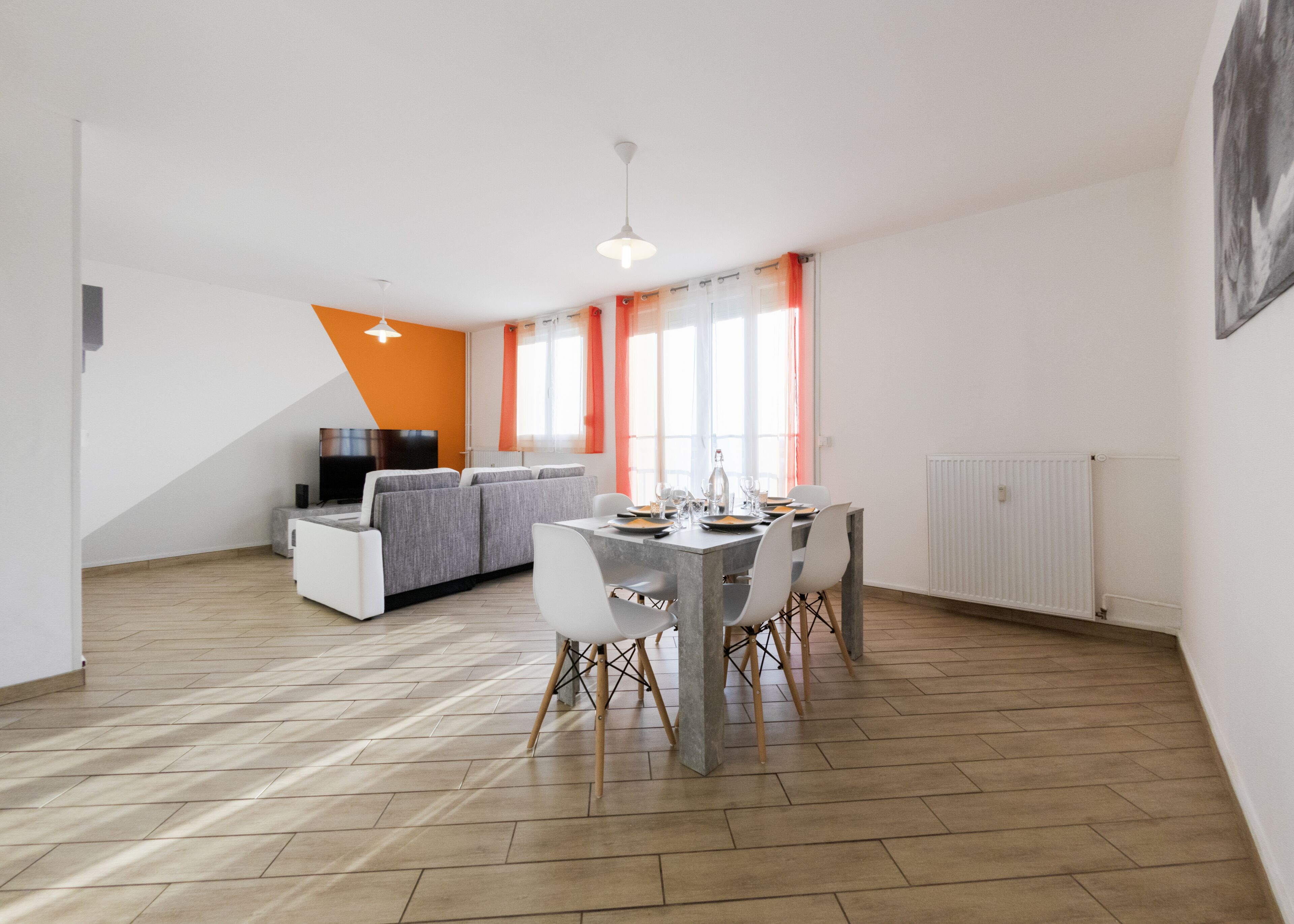 Un appartement moderne comprenant un coin repas, un salon et une cuisine.