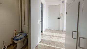 Casa de banho moderna com sanita, bidé e zona de duche.