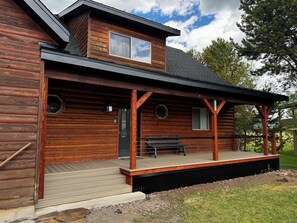 A log cabin with a porch, a covered deck, and a small front yard. - Black Bear Meadows - only 22 miles to West Yellowstone! (Island Park)