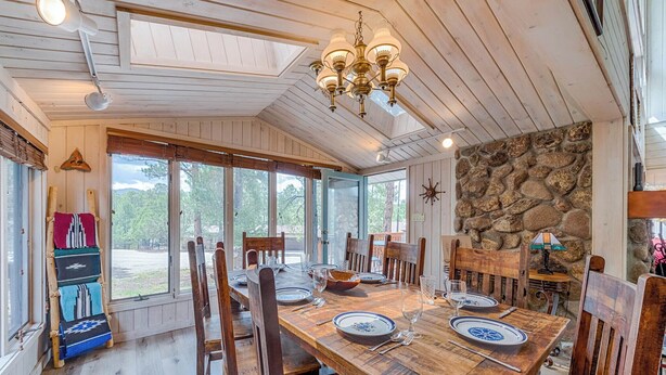 Un coin repas avec une table en bois dressée pour quatre personnes, entourée de chaises en bois.
