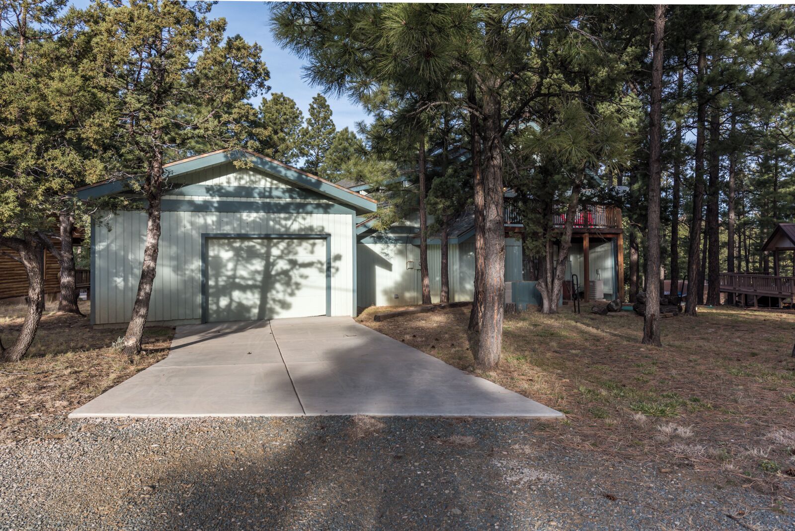 A single-story building with a garage, surrounded by trees.