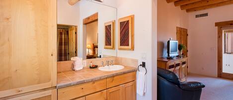 A wooden bathroom with a sink, mirror, and wooden cabinets.