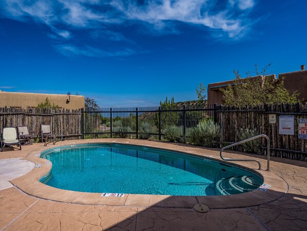 Relax by the serene pool surrounded by a deck and lounge chairs.