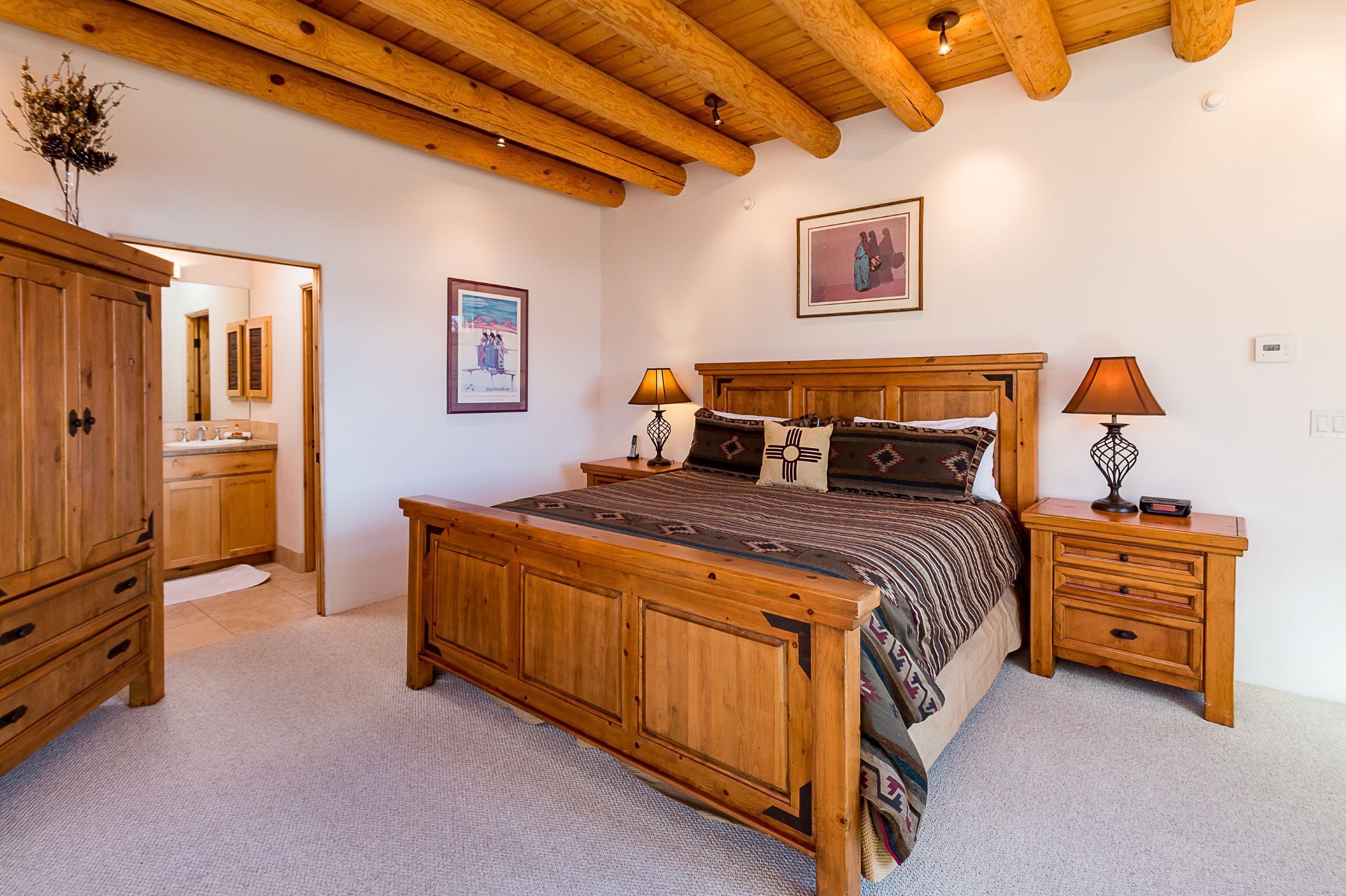 A bedroom with a wooden bed, nightstands, a wardrobe, and a large mirror.