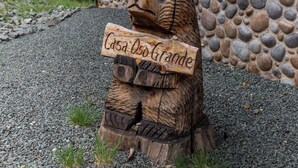 A wooden bear sculpture holding a sign that reads "Casa Usando Grande". - Casa Oso Grande by Ruidoso Vacation Rentals (Ruidoso)