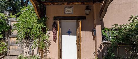 A rustic building with a wooden door and a sign above it.