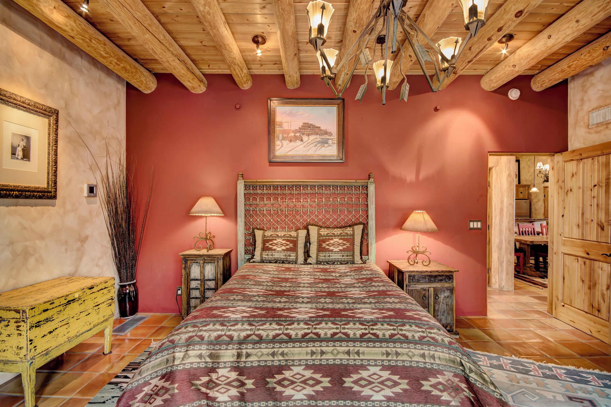Une chambre à coucher avec un plafond en bois, une couvre-lit à motifs et deux lampes de chevet.
