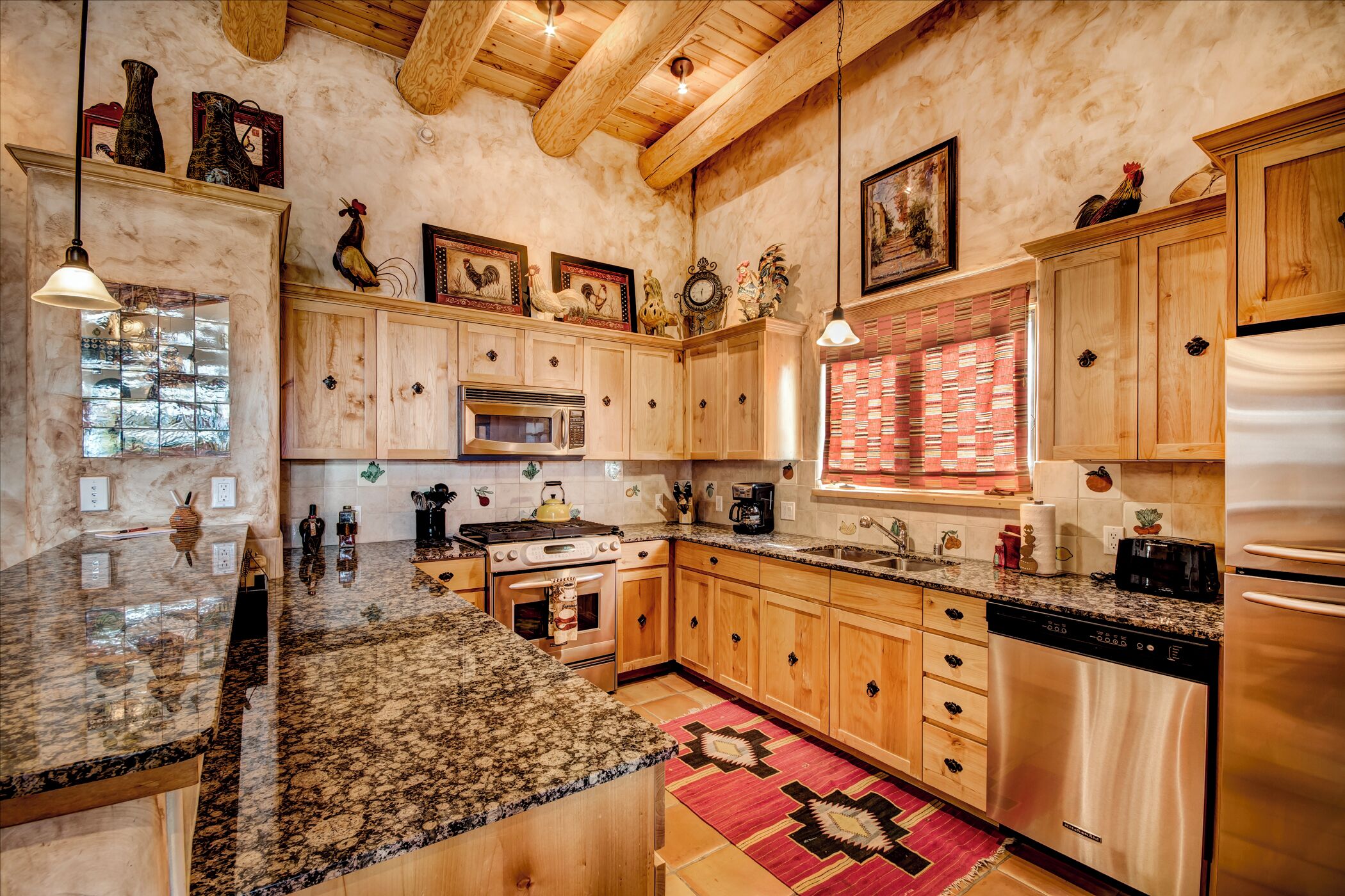 A kitchen with wooden cabinets, granite countertops, stainless steel appliances, and decorative items.