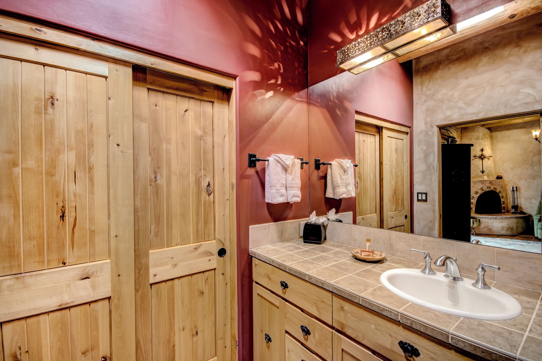 A bathroom with wooden cabinets, a sink, and a mirror.