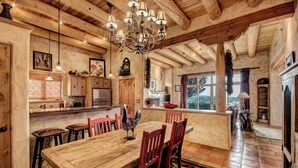 Una cucina rustica con travi in legno, un grande tavolo da pranzo in legno e un lampadario.