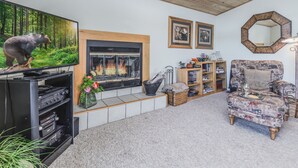 Ein Wohnzimmer mit Kamin, Fernseher und Bücherregal.