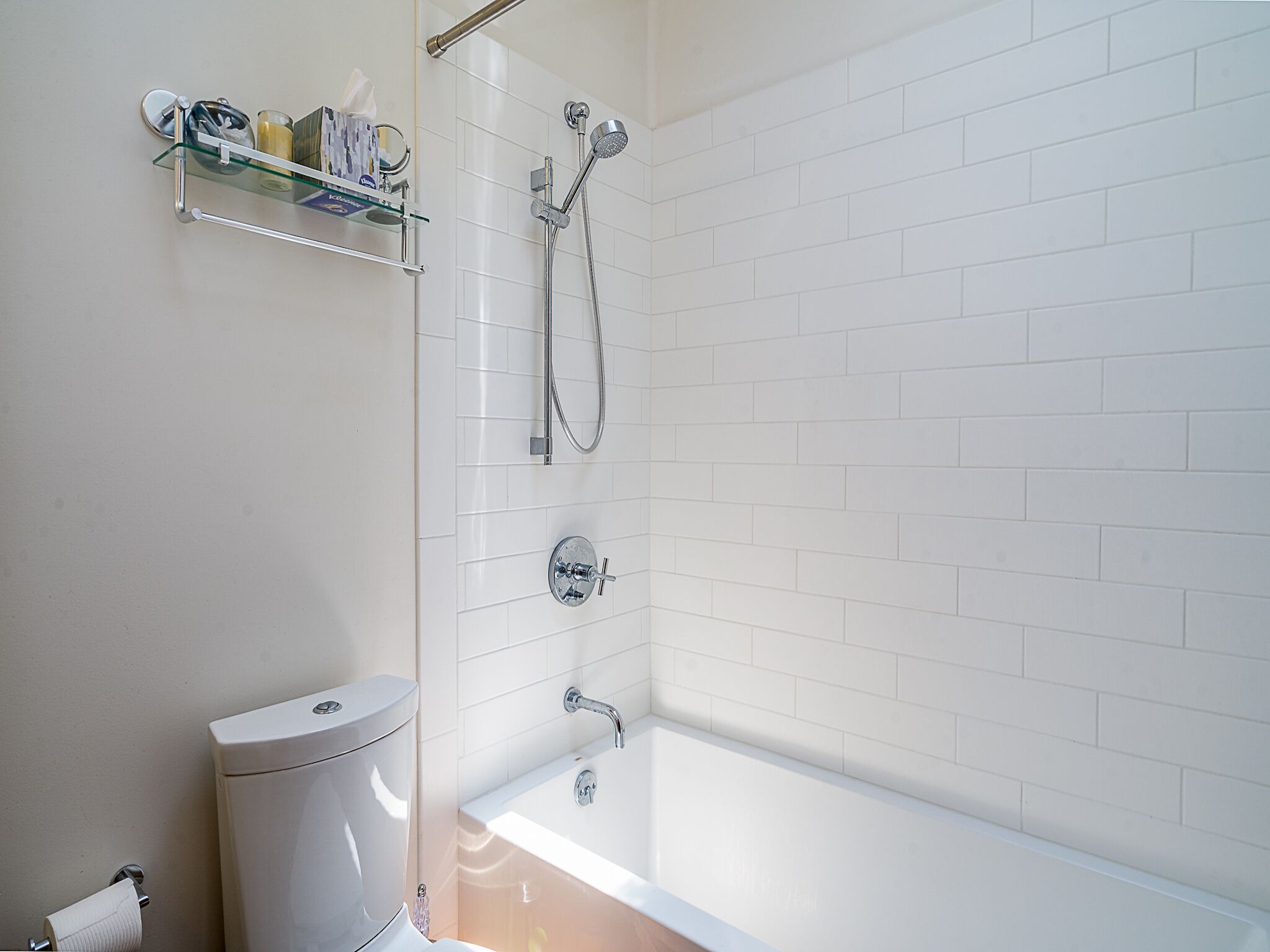 A modern bathroom with a glass shower enclosure, a white toilet, and a bathtub.