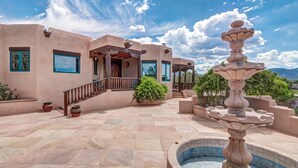 A courtyard with a fountain, a pool, and a building with a balcony. - Dorthia Garden Retreat & Views by Kokopelli Property Management (Santa Fe)