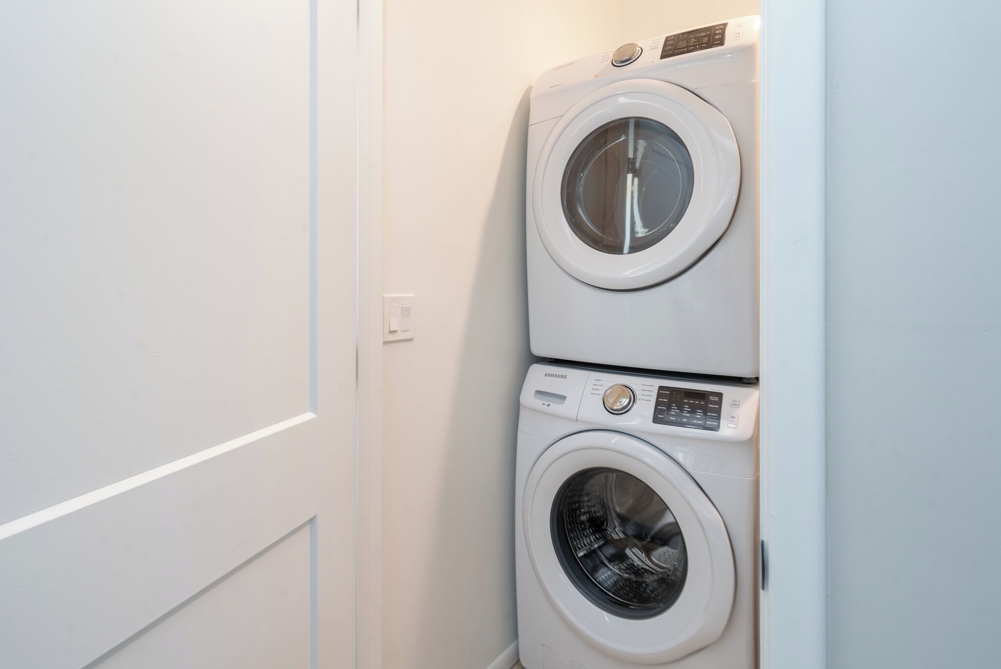 A compact laundry area with two stacked washing machines.