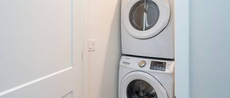 A compact laundry area with two stacked washing machines.