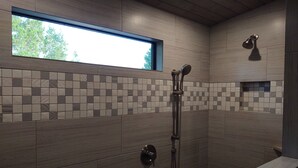 A modern bathroom with a shower, a window, and a tiled backsplash. - Absolute Repose - Secluded Cottage (Stonewall)