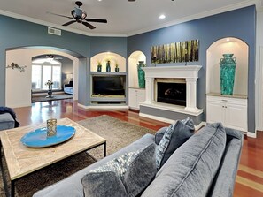 A living room with a grey sofa, a coffee table, a fireplace, and a TV. - Gathering Place by Ruidoso Vacation Rentals (Ruidoso)