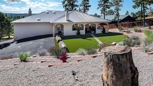Une maison de plain-pied dotée d’un patio couvert, d’une pelouse bien entretenue et d’une allée en gravier.