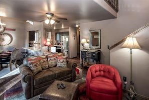 Relax in style with a comfortable leather sofa, coffee table, and rustic dining area.