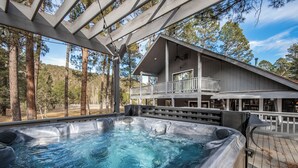 Ein Bereich mit Whirlpool, einer Holzterrasse und einem Haus im Hintergrund.