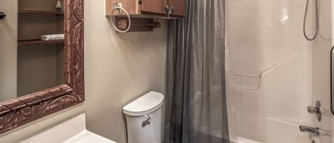 Une salle de bain avec des toilettes, un lavabo et une douche.