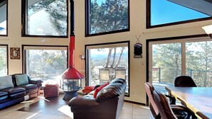 A spacious living area with a large sofa, a dining table, and a red hanging light fixture. - Gray Wolf Lodge by Ruidoso Vacation Rentals (Ruidoso)