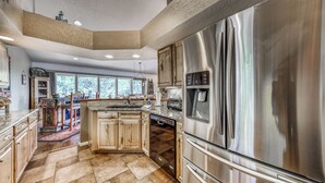 Una cucina moderna con elettrodomestici in acciaio inossidabile, mobili in legno e una grande isola.