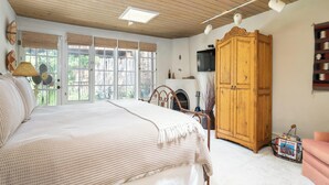 Un dormitorio con una cama grande, techo de madera y un armario.