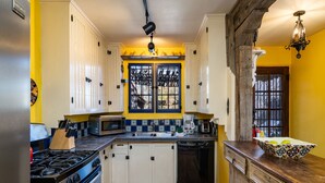 A kitchen with white cabinets, a stove, a microwave, and a dishwasher. - La Vida Buena by Kokopelli Property Management (Santa Fe)
