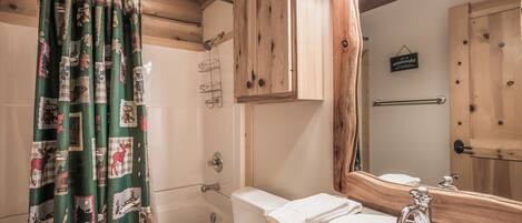 A bathroom with a toilet, sink, and shower area.