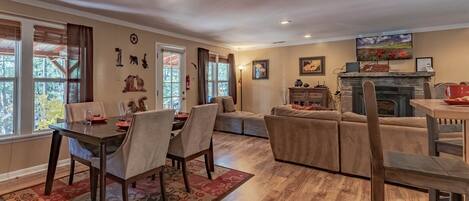 A spacious living room with a fireplace, a dining area, and a cozy seating arrangement.