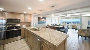 Une cuisine moderne dotée d’appareils électroménagers en acier inoxydable, de plans de travail en granit et d’un coin repas offrant une vue agréable.