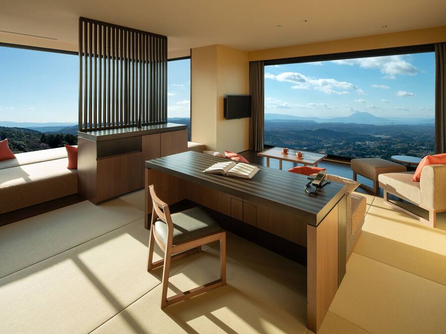 Quarto de hotel moderno com uma grande janela que oferece uma vista panorâmica da paisagem.