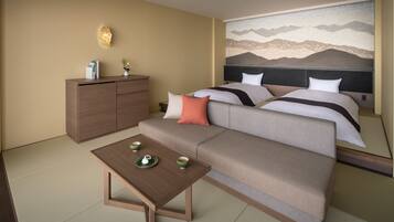 A hotel room with a sofa bed, a small table with tea set, a cabinet, and a wall mural.