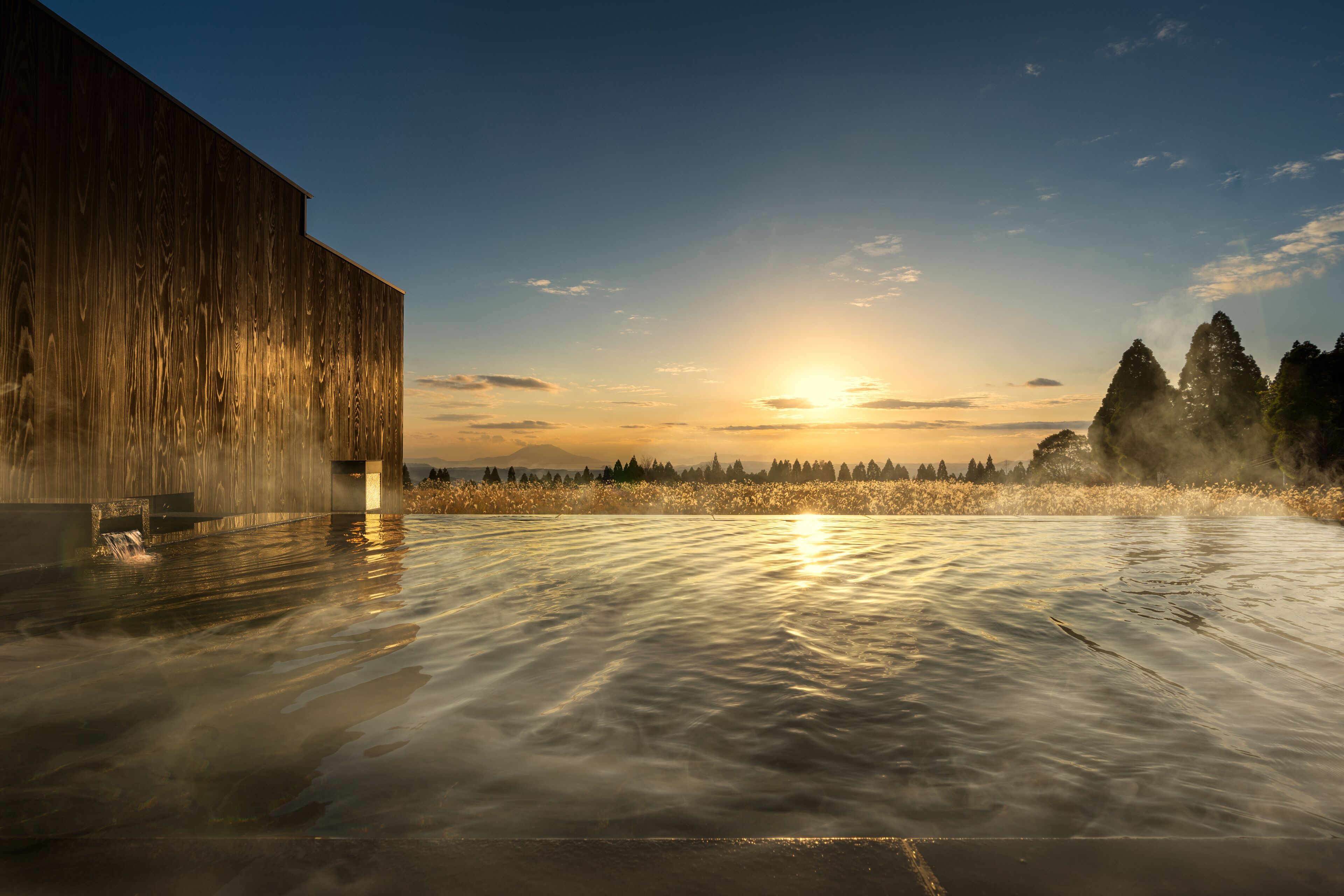 A large wooden building with a reflective water surface in front.