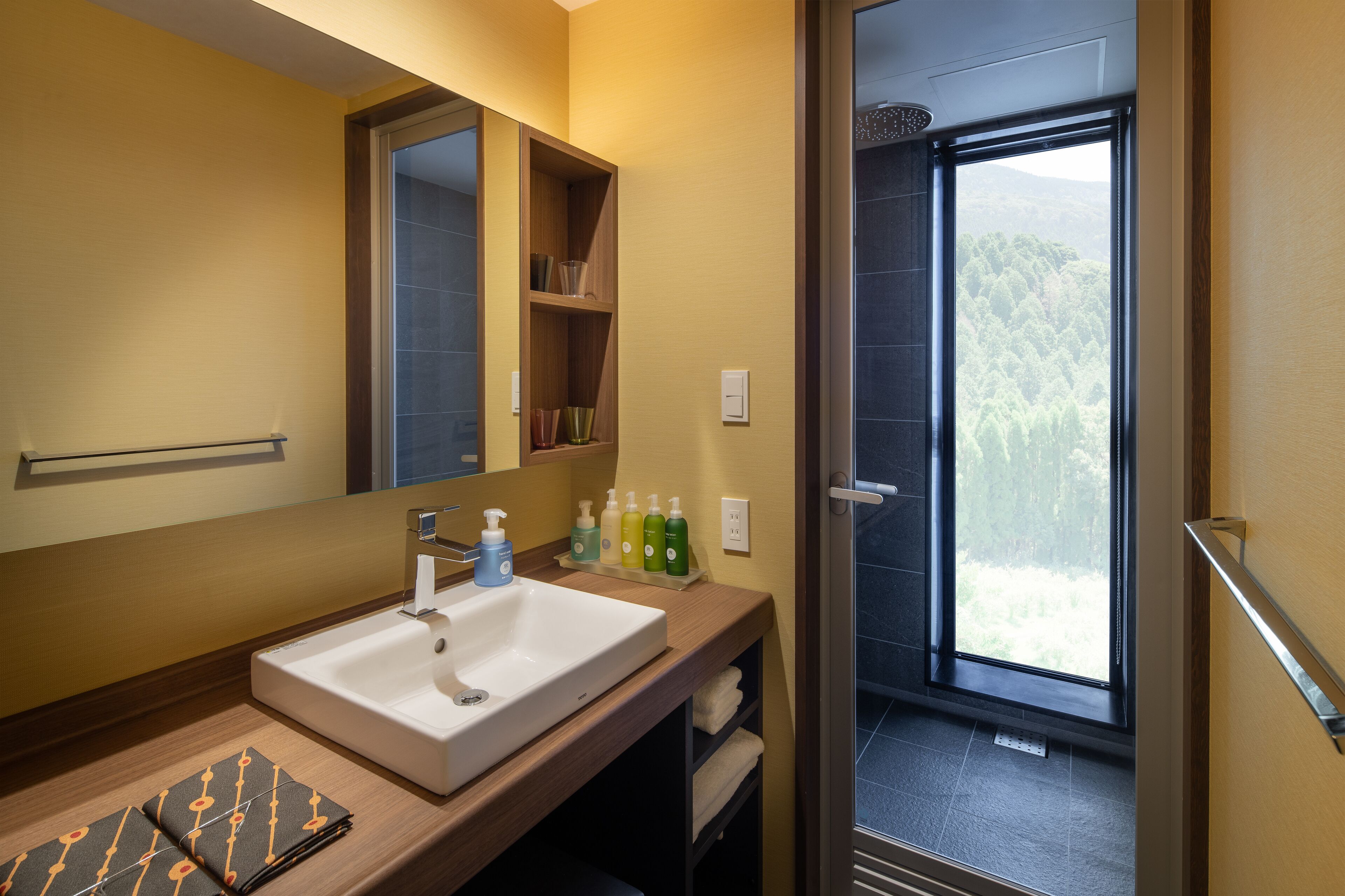 Ein Badezimmer mit Waschbecken, Spiegel und Ablagen für Toilettenartikel.