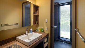 A bathroom with a sink, mirror, and shelves with toiletries.