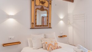 A bedroom with a bed, a mirror, bedside tables, and a towel rack. - Holiday Home "Can Raixa" with Private Pool, Private Terrace and Wi-Fi (LLOSETA)