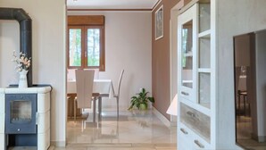 A modern kitchen with a built-in stove, a dining area with a table and chairs, and a view of the outdoors through a window. - Villa Aniva by Interhome (Rovinj/Žminj)