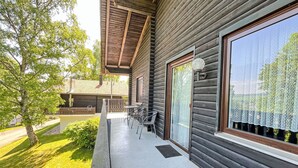 Eine Holzhütte mit Balkon, Tisch und Stühlen.
