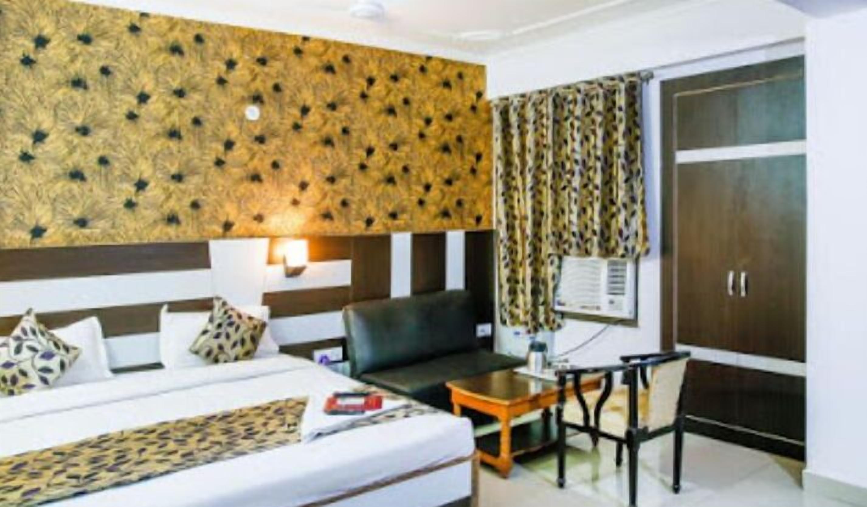 Una habitación de hotel con una cama, un sofá, una mesita y un armario.