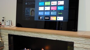 A flat-screen TV mounted on a wall with a digital interface displaying various streaming services. - Pres De La Mer (Hakodate)