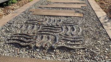 A pathway with wooden planks and a decorative metal pattern.