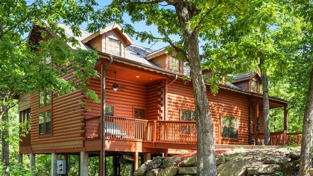 A log cabin with a balcony, surrounded by trees. - Roomy 2BR+Loft Walk-in Cabin near Shows, Shopping, and Dining! (Branson)