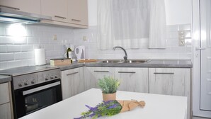 Une cuisine moderne avec des armoires blanches, une cuisinière en acier inoxydable et un évier.