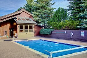 Una baita in legno con piscina, immersa nel verde.