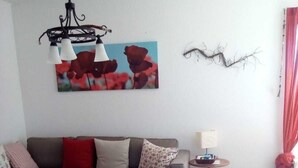 Un salon avec un canapé, une table basse, une lampe et un tableau au mur.
