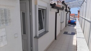 A corridor with a tiled floor, a door, a window with a curtain, and a blue object on the right. - Sea View Apartment in Okrug Gornji near Trogir Center (Okrug)