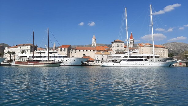 A marina with several yachts docked, a historic building with a tower, and calm water. - Sea View Apartment in Okrug Gornji near Trogir Center (Okrug)