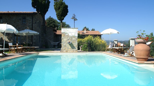 A pool area with stone buildings, outdoor seating, and umbrellas. - Holiday Home in Montecarelli With Pool (Barberino di Mugello)